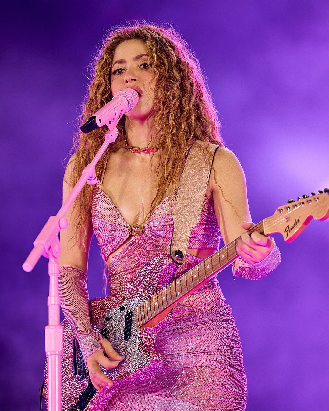 Shakira playing guitar with a custom Red Monkey guitar strap designed for the Las Mujeres Ya No Lloran World Tour