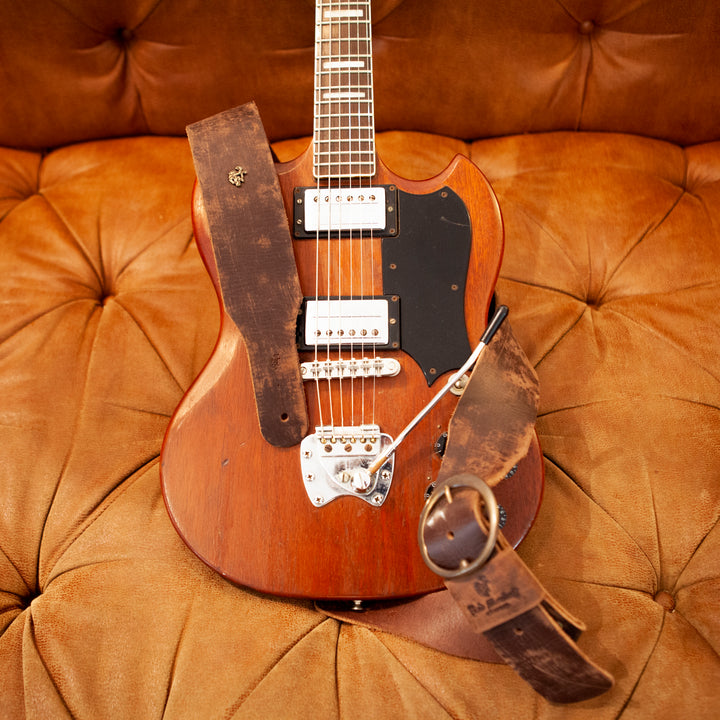 Vintage guitar strap in distressed leather hanging a Vintage Gibson SG