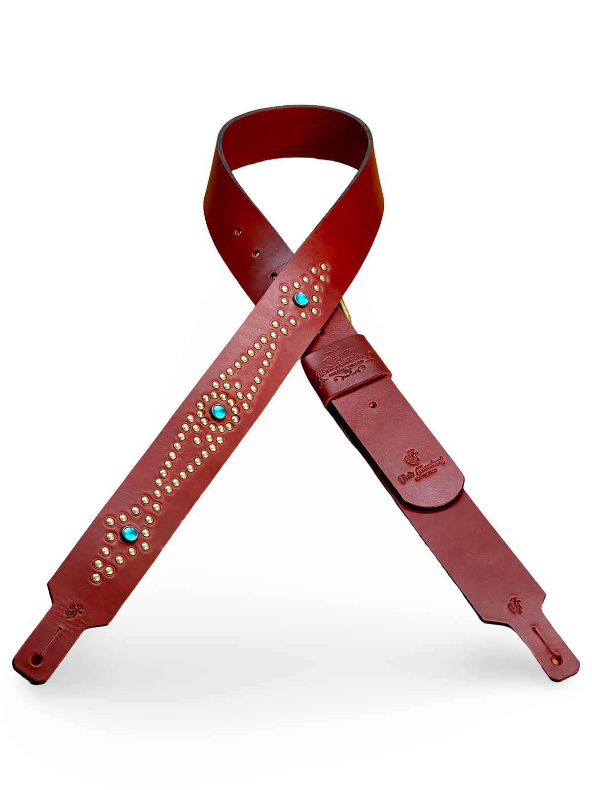 Red Monkey leather guitar strap shown full length with mounting holes, adjustment section, leather body, and decorative hand-set detailing.
