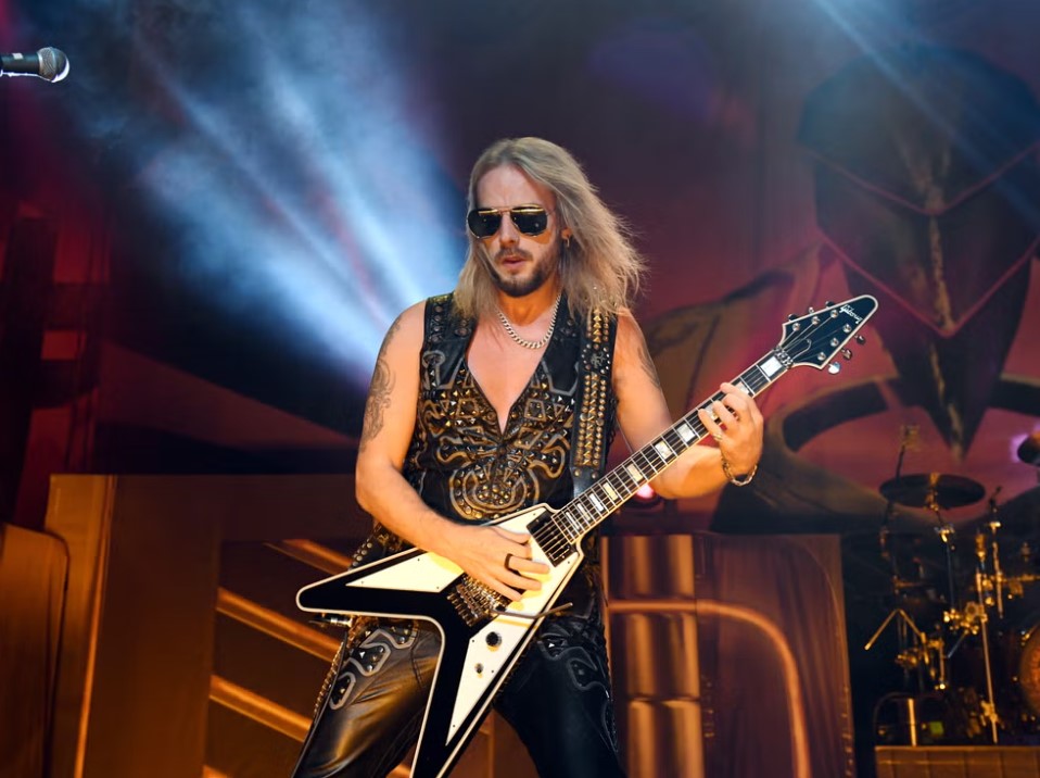 Richie Faulkner of Judas Priest performing with a Gibson Flying V and Red Monkey leather guitar strap