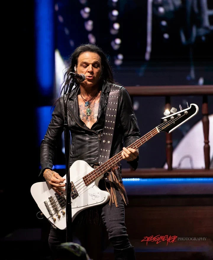 Chuck Garric performing with Alice Cooper while wearing a Red Monkey leather bass strap designed for comfort and support.