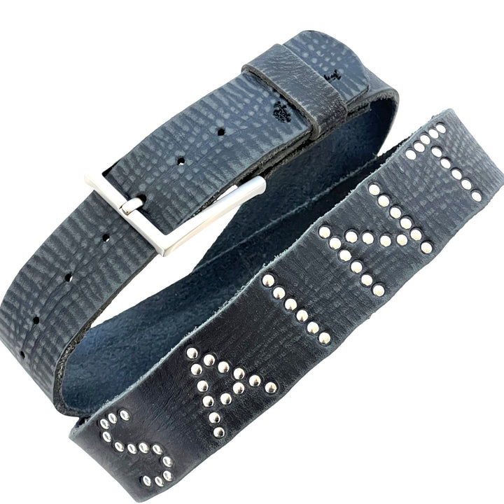 Close-up of Saint Studded Belt with silver stud lettering on distressed black leather