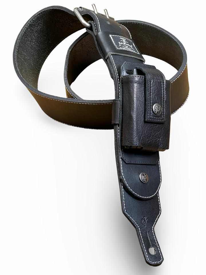 Wireless pack holder installed on black leather guitar strap with cable attached