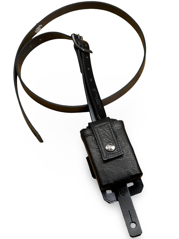 Wireless pack transmitter holder mounted on a black leather guitar strap
