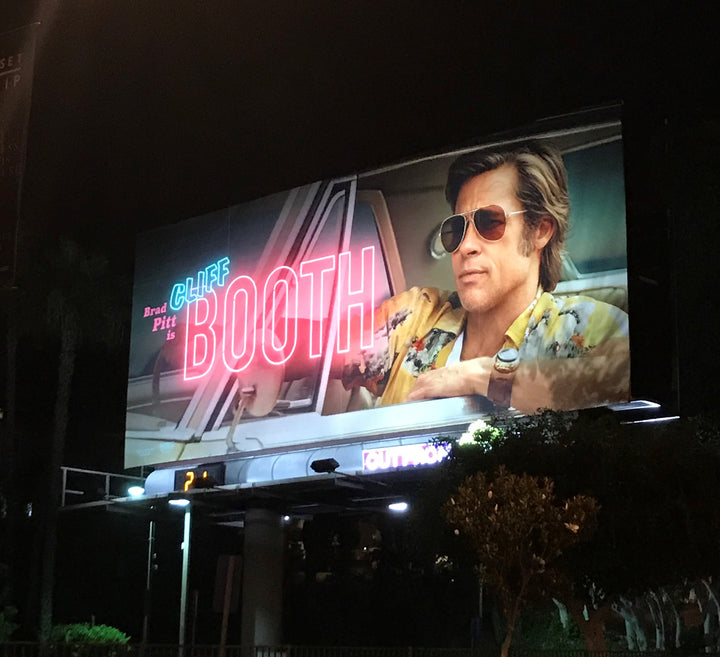 Billboard of Brad Pitt as Cliff Booth on the Sunset Strip wearing his Red Monkey cuff watch