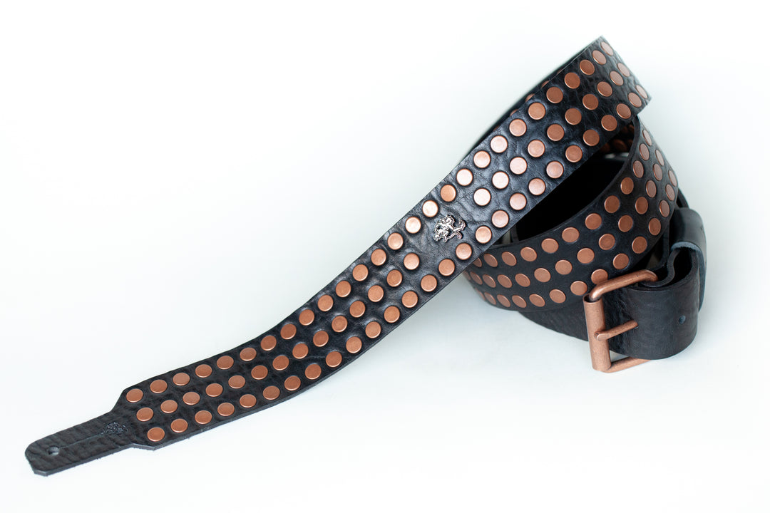 Copper colored rivets on leather guitar strap with adjustable buckle
